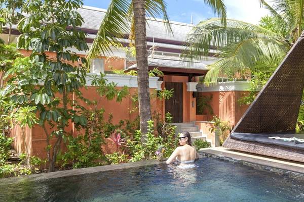 Eine Frau schwimmt im Pool vor dem Beyond Resort Khao Lak.
