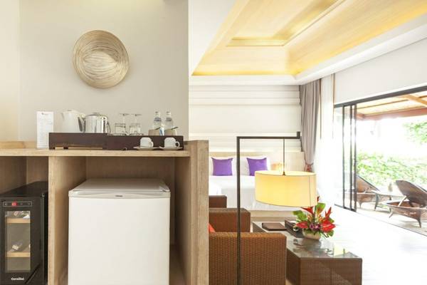 Innenansicht der Suite im Beyond Resort Khao Lak mit Minibar, Kühlschrank und Wohnzimmerbereich.