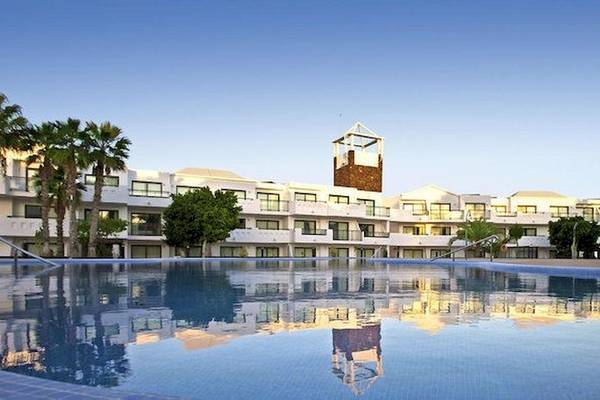 Außenpool des Be Live Experience Lanzarote Beach Hotels mit spiegelnden Wasser und Gebäude im Hintergrund