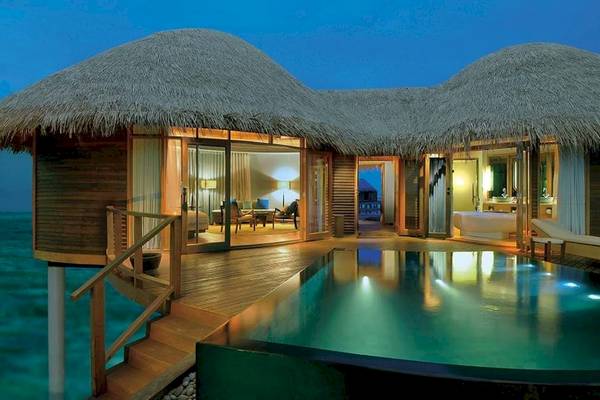 Wasserbungalow im Constance Halaveli Maldives bei Nacht mit Blick auf das Meer.