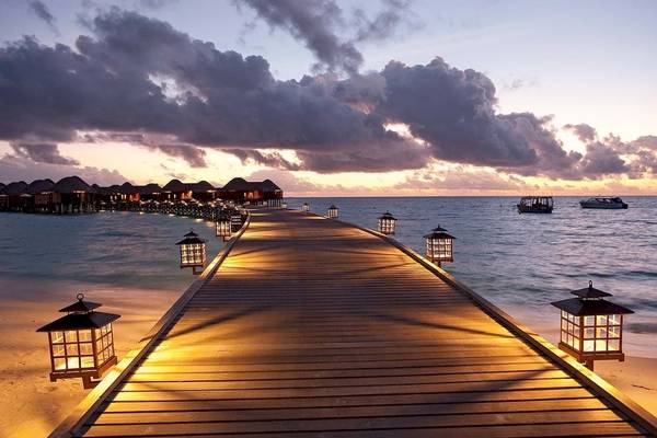 Sonnenuntergang am Constance Halaveli Maldives mit beleuchtetem Steg