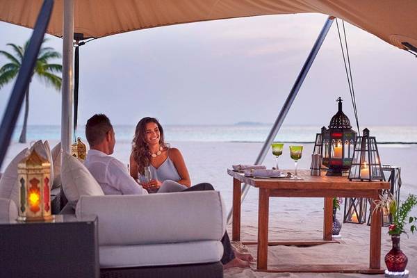 Paar auf Couch bei Sonnenuntergang im Constance Halaveli Maldives