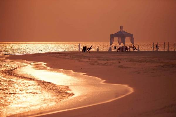 Strandszene mit einem Zelt am Constance Halaveli Hotel in den Malediven bei Sonnenuntergang.