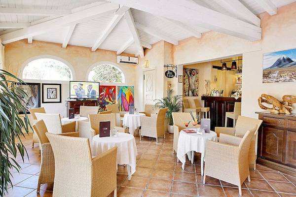 Restaurantbereich des Colonna Country & Sporting Club mit runden Tischen und Stühlen.