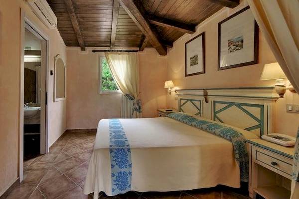 Ein Hotelzimmer im Colonna Country & Sporting Club mit einem Bett, Fernseher und Dekor.