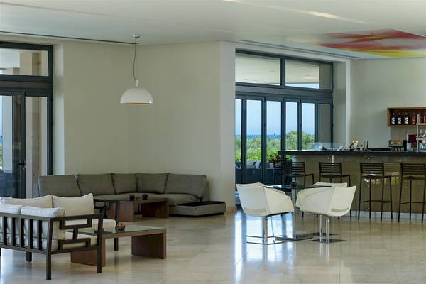 Lobby des Atlantica Eleon Grand Resort mit Couch, Tischen und Bar.