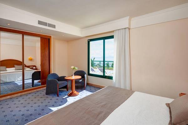 Hotelzimmer im Hipotels Natura Palace mit Meerblick, zwei Betten, einem Tisch und Stühlen.