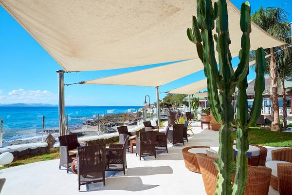 Terrasse des Hipotels Natura Palace mit Sofas, Kakteen und Meerblick.