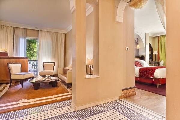 Innenansicht der Suite im Palmeraie Palace mit Wohnzimmer und Schlafzimmerbereich.