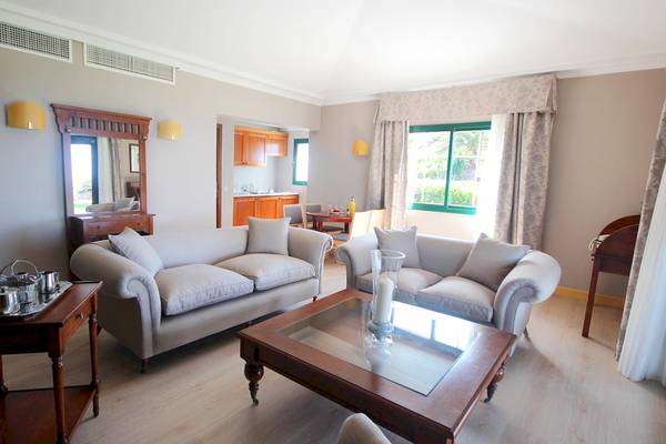 Wohnzimmer im Hipotels Natura Palace mit zwei Sofas, einem Tisch und einem Kamin.