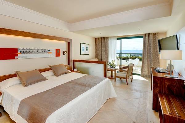 Hotelzimmer im Hipotels Natura Palace mit Blick auf das Meer und einem großen Bett.