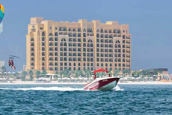 Doppelbaum Hilton Resort & Spa Marjan Insel mit Parasailing und Boot auf dem Wasser.