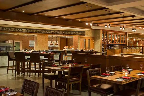 Das innenbereich des DoubleTree by Hilton Resort & Spa Marjan Island Restaurants mit vielen Tischen und Stühlen.