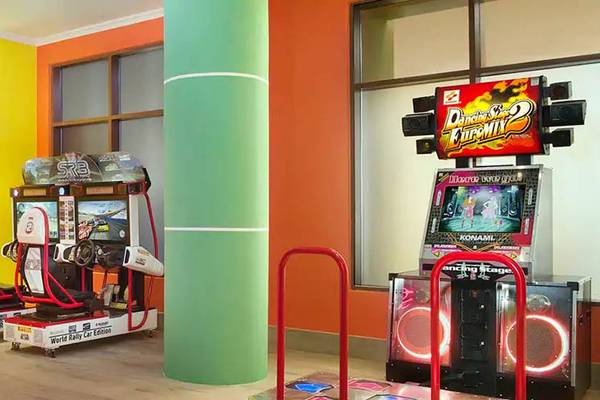 Spielraum im DoubleTree by Hilton Resort & Spa Marjan Island mit Arcade-Spielen und bunten Wänden