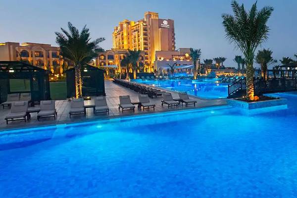 Außenpool des DoubleTree by Hilton Resort & Spa Marjan Island bei Nacht
