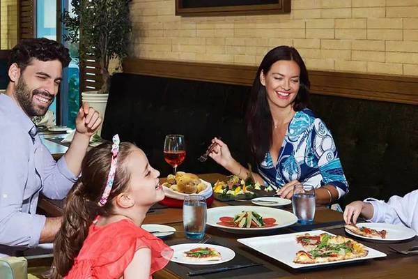 Eine Familie isst im Restaurant des DoubleTree by Hilton Resort & Spa Marjan Island.