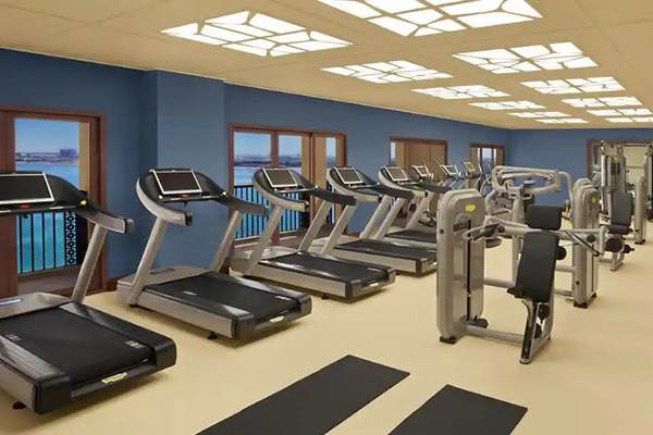 Fitnessstudio im DoubleTree by Hilton Resort & Spa Marjan Island mit Blick auf das Meer.