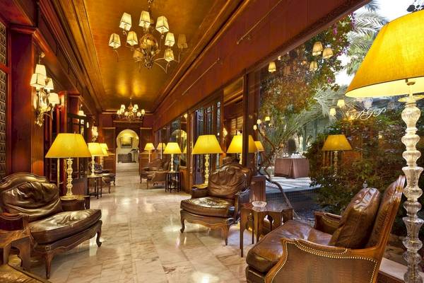 Innenansicht des Palmeraie Palace Hotels mit Lederstühlen und Kronleuchtern.