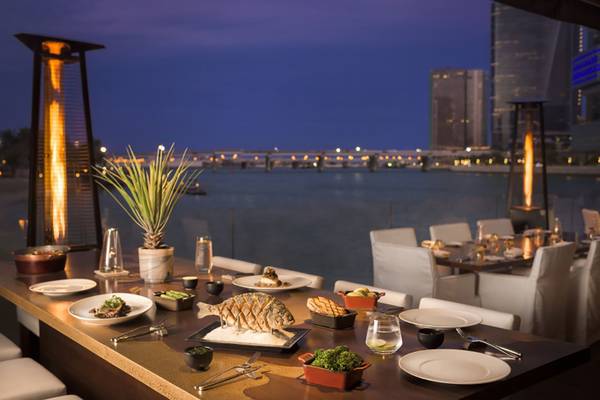 Abendessen auf der Terrasse des Beach Rotana mit Blick auf die Stadt und das Wasser.