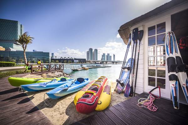 Wassersport-Equipment auf dem Strand vor dem Beach Rotana Hotel.