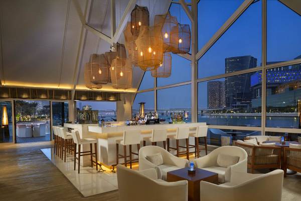 Barbereich im Beach Rotana Hotel mit Blick auf die Skyline und Wasser