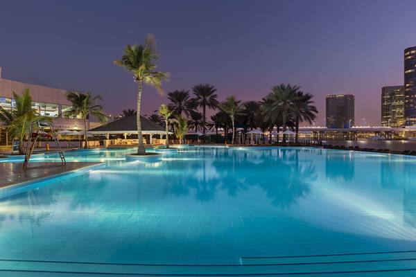Strand am Beach Rotana Hotel bei Nacht mit blauem Wasser und Palmen
