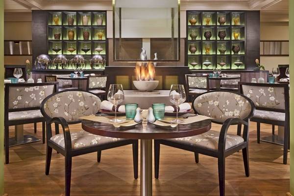 Innenansicht des Restaurants im Palmeraie Palace Hotel mit runden Tisch, Gläser und Teller.