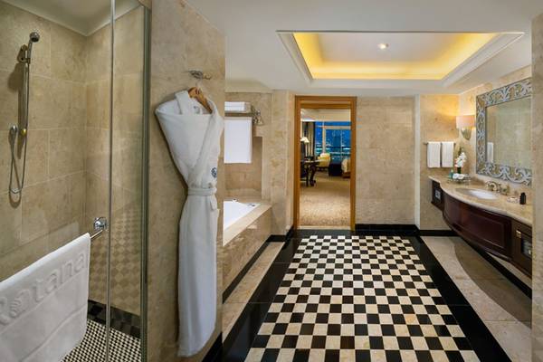 Badezimmer im Beach Rotana Hotel mit Badewanne, Dusche, Waschbecken und Marmorboden.