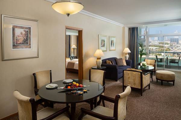 Innenansicht der Suite im Beach Rotana Hotel mit Essbereich und Wohnzimmer.