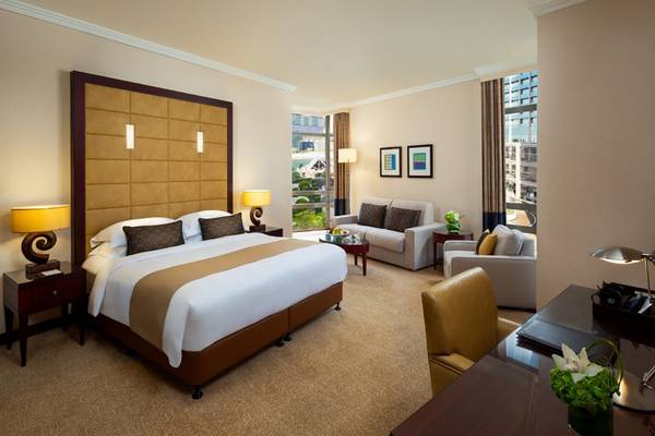 Beach Rotana Hotel Suite mit Doppelbett, Sofa, Schreibtisch und Fenstern.