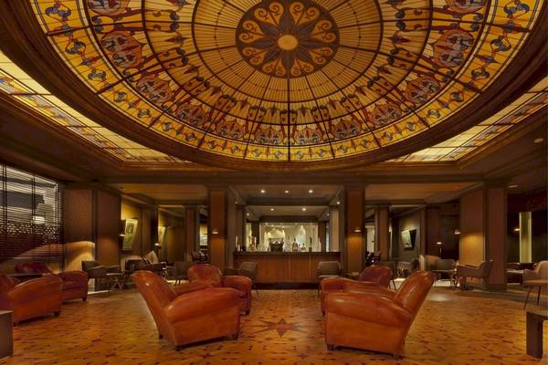 Palmeraie Palace Lobby mit Ledersesseln und farbiger Glaskuppel.