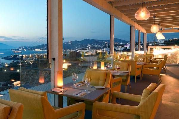 Terrasse des Myconian Korali Relais & Chateaux mit Blick auf das Meer und die Stadt.