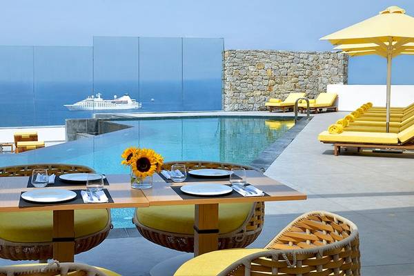 Außenpool-Terrasse mit Blick auf das Meer und eine Kreuzfahrt im Hintergrund