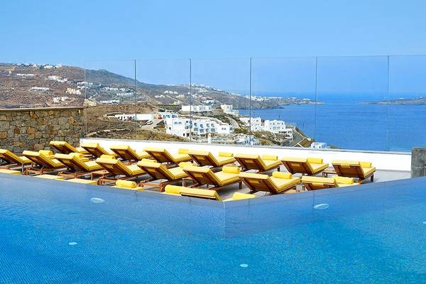 Pool des Myconian Korali Hotels mit Blick auf das Meer und Berge