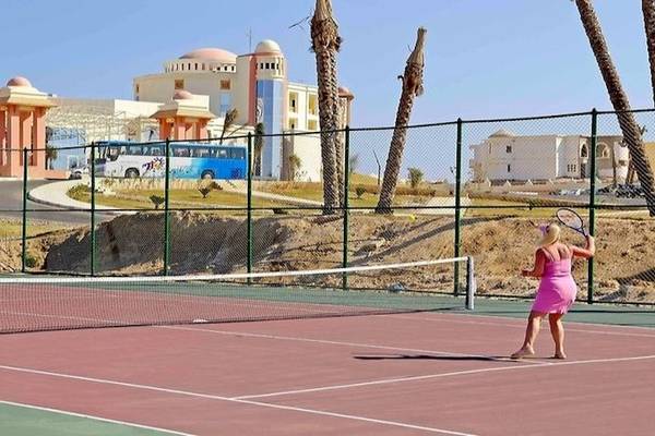Zwei Frauen spielen Tennis auf einem Tennisplatz im Serenity Alpha Beach Hotel.