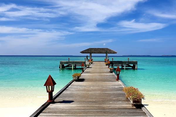 Holzsteg im Meer bei The Barefoot Eco Hotel mit blauem Himmel und Wasser