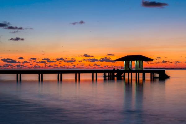 Barefoot Eco Hotel am Wasser bei Sonnenuntergang mit einer blauen und orangefarbenen Himmel.