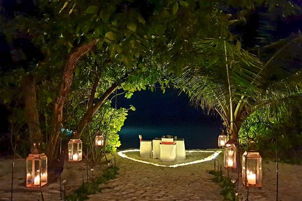 Romantisches Essen am Strand im Barefoot Eco Hotel mit brennenden Laternen.