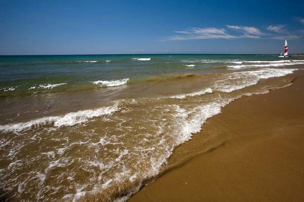 Defne Star Hotel Strand mit Wellen im Meer und Segelboot im Hintergrund