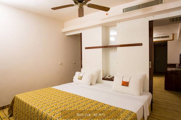 Suite-Zimmer im Defne Star Hotel mit Bett, Kissen, Telefon und Deckenventilator.
