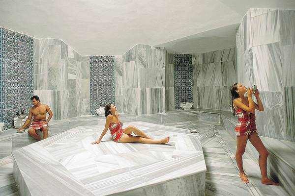 Ein Dampfbad im Defne Star Hotel mit drei Personen, zwei Frauen und einem Mann.