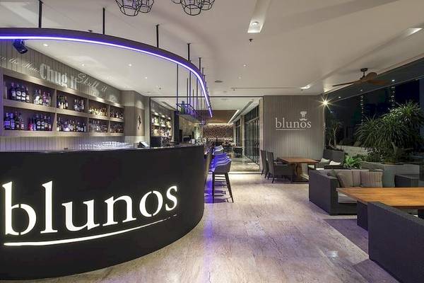 Die Blunos Bar im Eastin Grand Hotel Sathorn mit moderner Einrichtung und großen Fenstern.