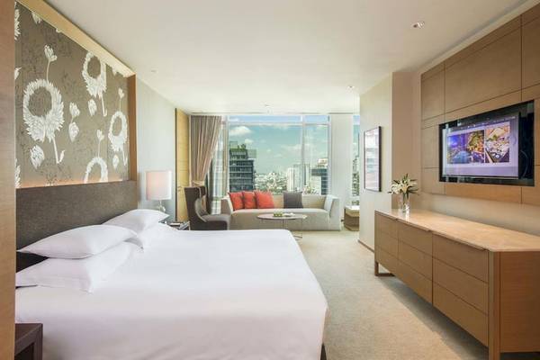 Schlafzimmer im Eastin Grand Hotel Sathorn mit großem Bett, Fernseher und Stadtblick.