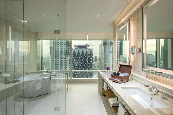 Badezimmer im Eastin Grand Hotel Sathorn mit Badewanne und Ausblick auf die Stadt.