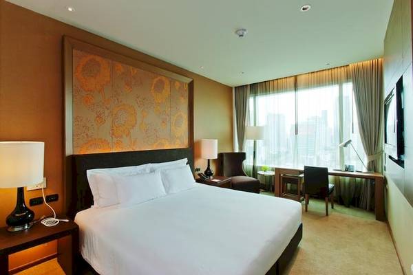 Luxuriöses Zimmer im Eastin Grand Hotel Sathorn mit großem Bett, Dekor und Fenstern.