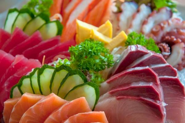 Eine Auswahl verschiedener Fischplatten, einschließlich Thunfisch, Lachs und Tintenfisch, auf Eis serviert.