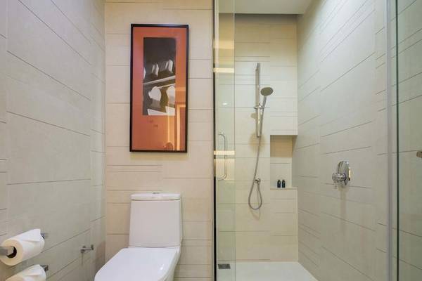 Badezimmer im Eastin Grand Hotel Sathorn mit Dusche, Toilette und Toilettenpapierhalter.