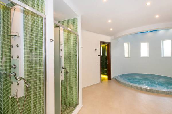 Ein Badezimmer im Iberostar Creta Panorama & Mare mit grünen Fliesen, einer Regendusche und einer Badewanne.