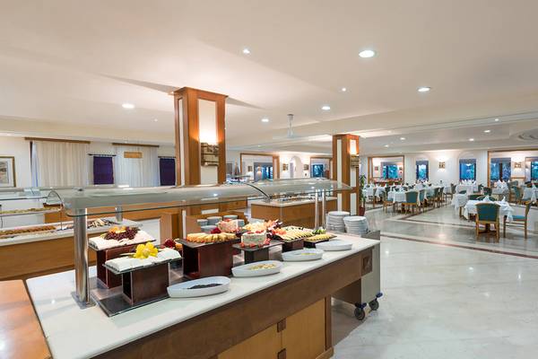 Innenansicht des Buffet-Restaurants im Iberostar Creta Panorama & Mare Hotel mit vielen Speisen und gedeckten Tischen.