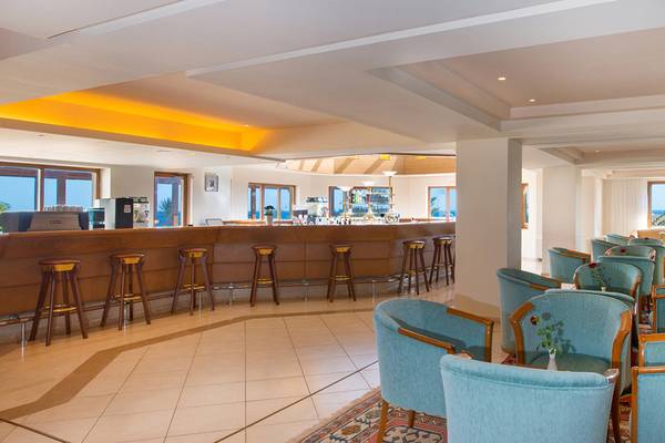 Innenansicht der Bar im Iberostar Creta Panorama & Mare Hotel mit Barhockern und blauen Stühlen.